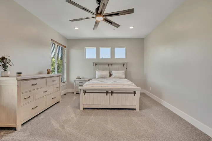 Recessed lighting, ceiling fan with wood-finish blades, and multiple windows with blinds