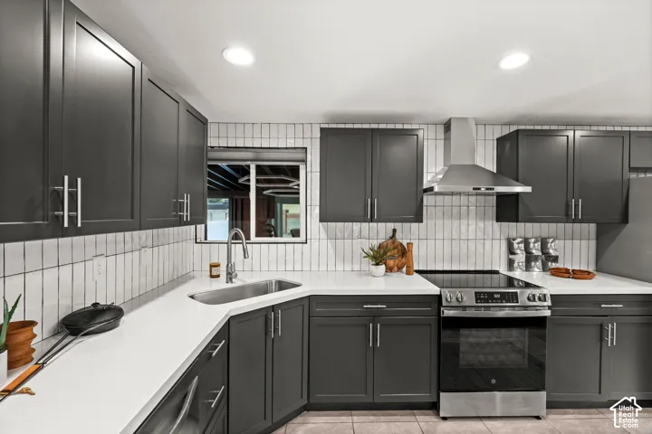 Modern kitchen featuring dark cabinetry, white countertops, a tile backsplash, stainless steel appliances, and recessed lighting