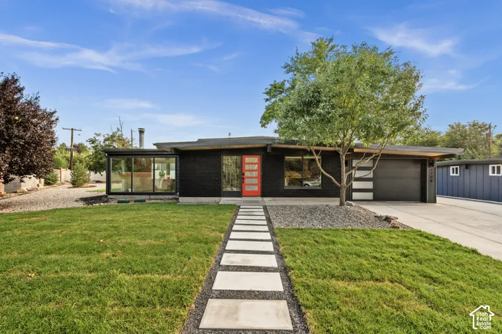 Modern exterior with black brick and an orange front door