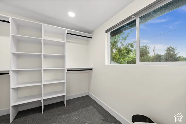 Custom built-in shelving, integrated hanging rods, recessed ceiling light, and a large window