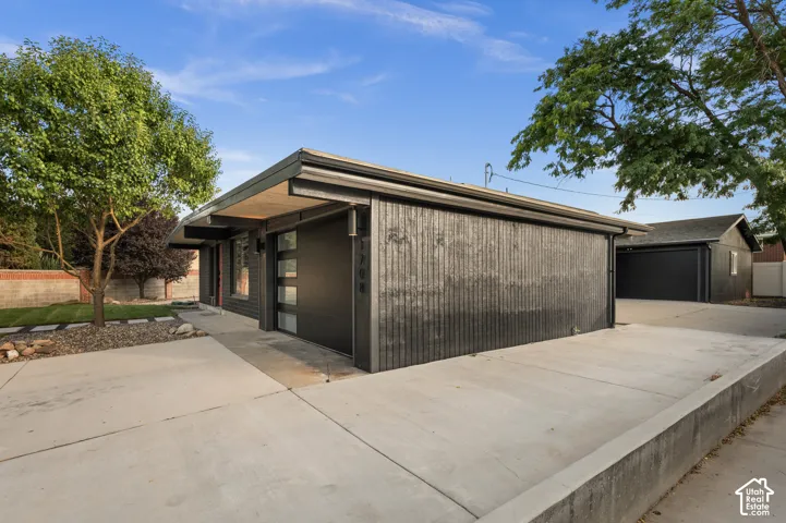 Contemporary dark-toned exterior with a flat roofline and a modern garage door featuring frosted glass panels