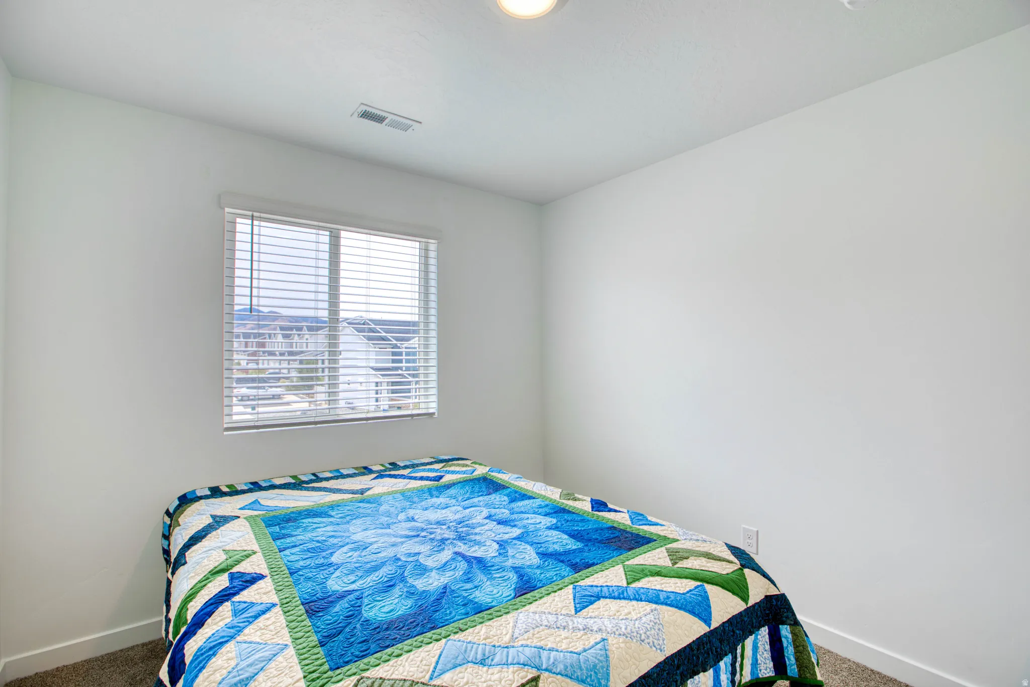 Recessed lighting, wall-to-wall carpeting, and a window with blinds