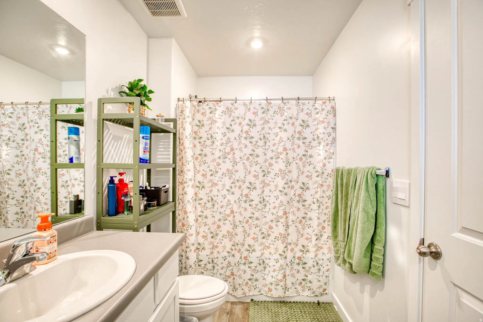 Vanity with integrated sink, chrome faucet, and expansive wall mirror