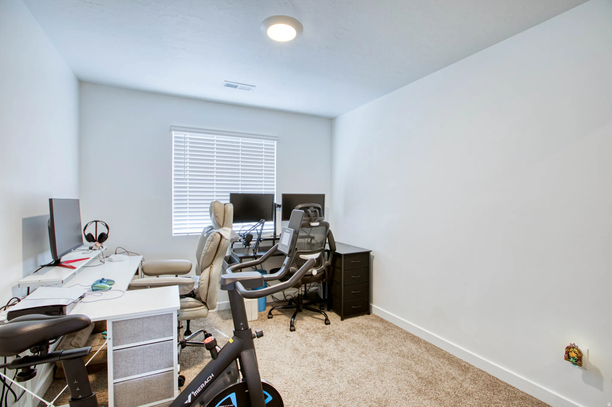 Recessed ceiling light, neutral wall paint, carpet flooring, window with blinds