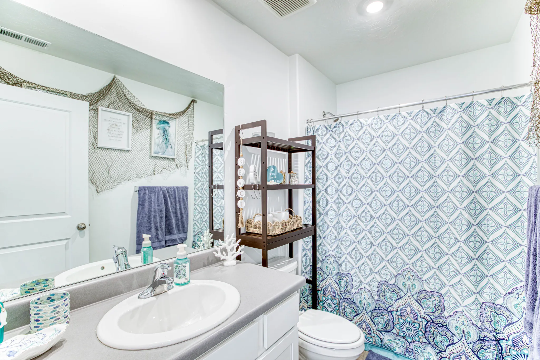 White vanity with integrated oval sink, chrome faucet, and gray countertop