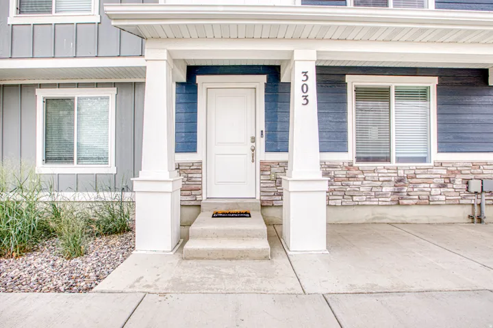 Covered entry with white columns and concrete steps