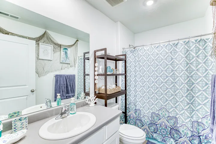 White vanity with integrated oval sink, chrome faucet, and gray countertop