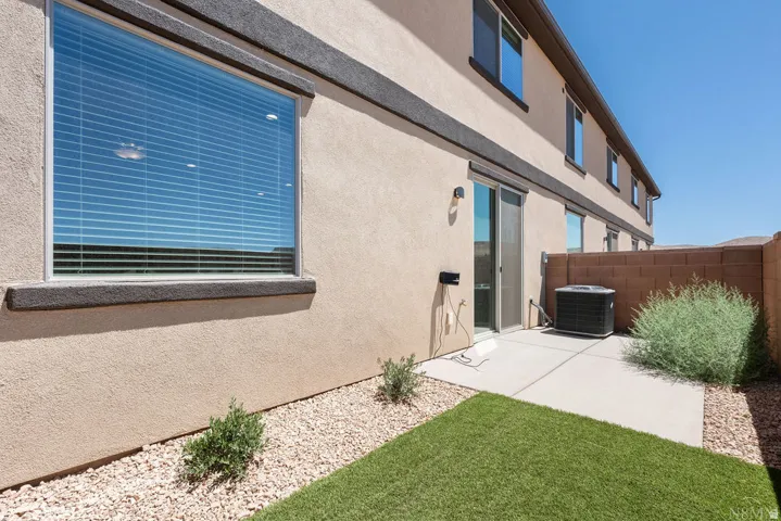 Private patio with artificial turf and decorative rock landscaping