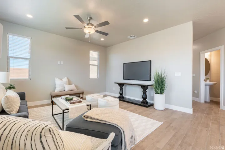 Recessed lighting, ceiling fan with integrated light, multiple windows, wood-finish flooring, and a pedestal sink