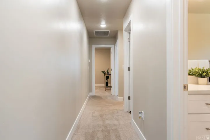 Recessed ceiling lighting, light-toned wall paint, carpet flooring, and white trim