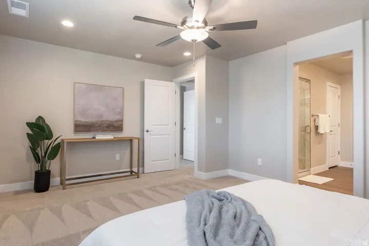 Recessed lighting, ceiling fan, carpeted flooring, and a glass-enclosed shower with tile surround