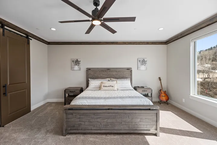 Carpeted flooring with recessed lighting, a ceiling fan, and a barn door entry