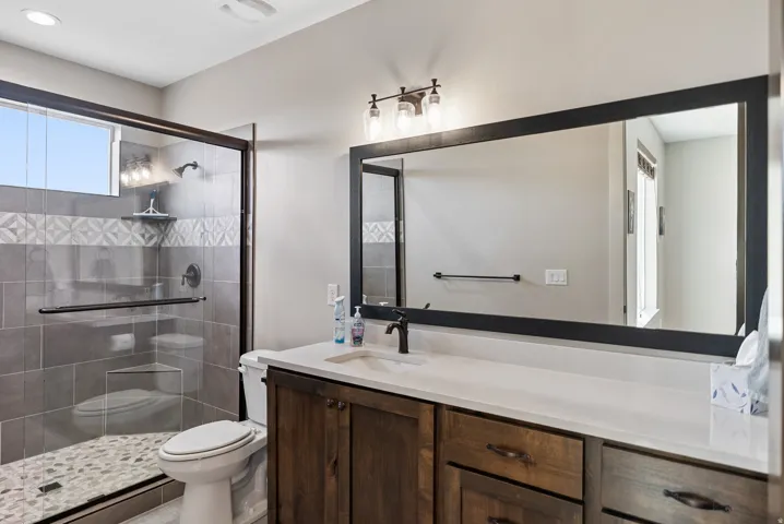 Glass-enclosed shower with tile surround and pebble flooring