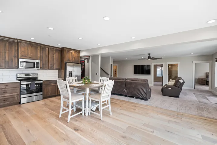 Spacious open-concept living area featuring wood-finish flooring, recessed lighting, and a ceiling fan
