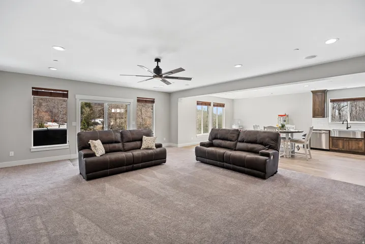 Recessed lighting, ceiling fan, sliding glass door, wood-finish flooring, and a subway tile backsplash