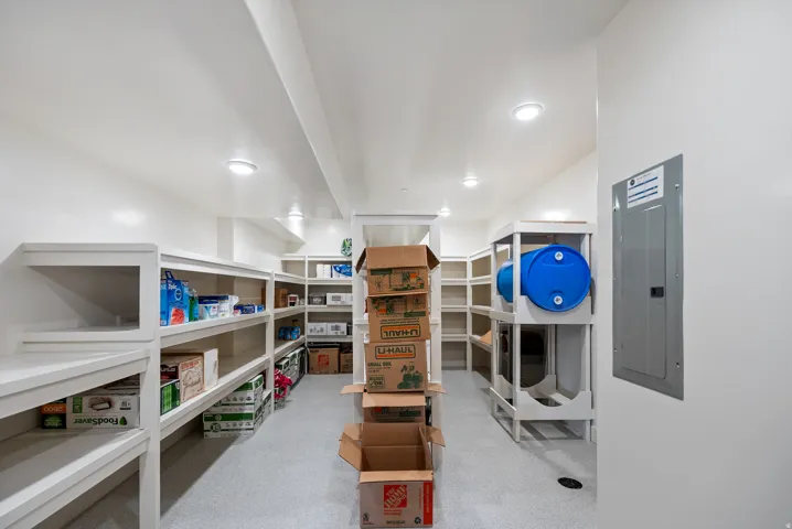 Spacious pantry featuring extensive built-in shelving, recessed lighting, and durable flooring