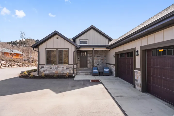 Contemporary exterior with mixed material siding, stone accents, and dark trim