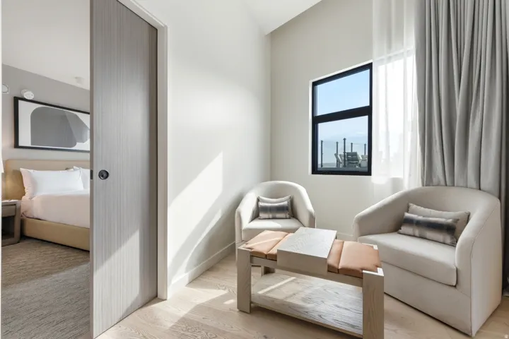 Light wood-finish flooring, high ceilings, and a large window with black framing
