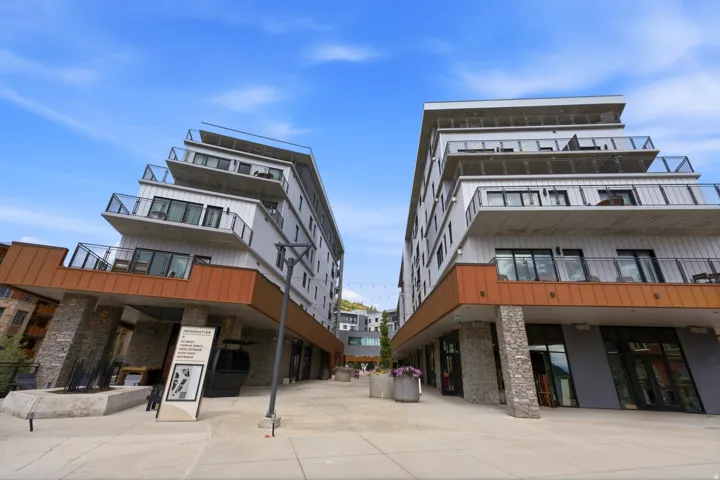 Modern multi-story buildings featuring stacked balconies with glass railings