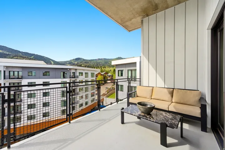 Balcony with metal grid railing, concrete flooring, and vertical paneling