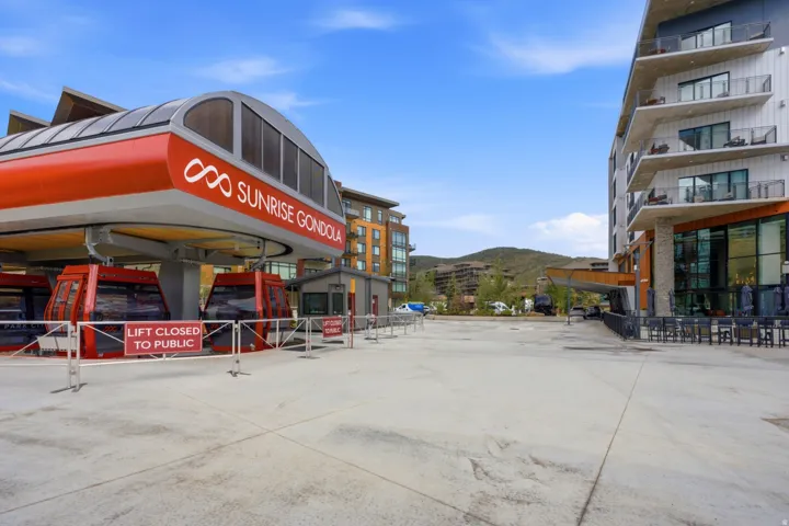 Sunrise Gondola station with multi-story buildings featuring private balconies, expansive windows, and a paved outdoor area