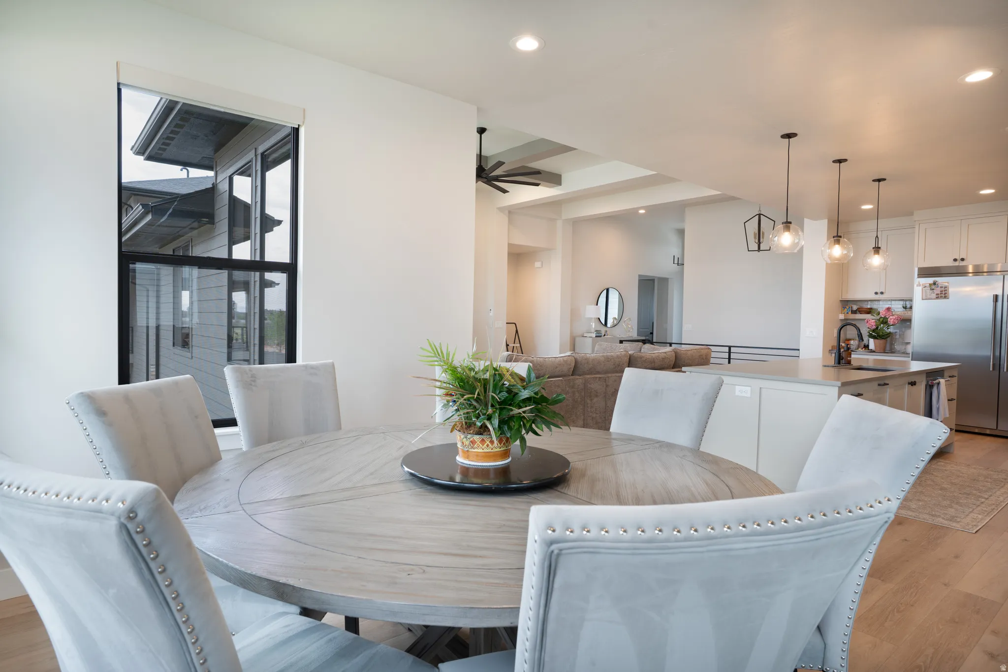 Open-concept living space featuring wood-finish flooring, recessed lighting, and kitchen island with pendant lighting