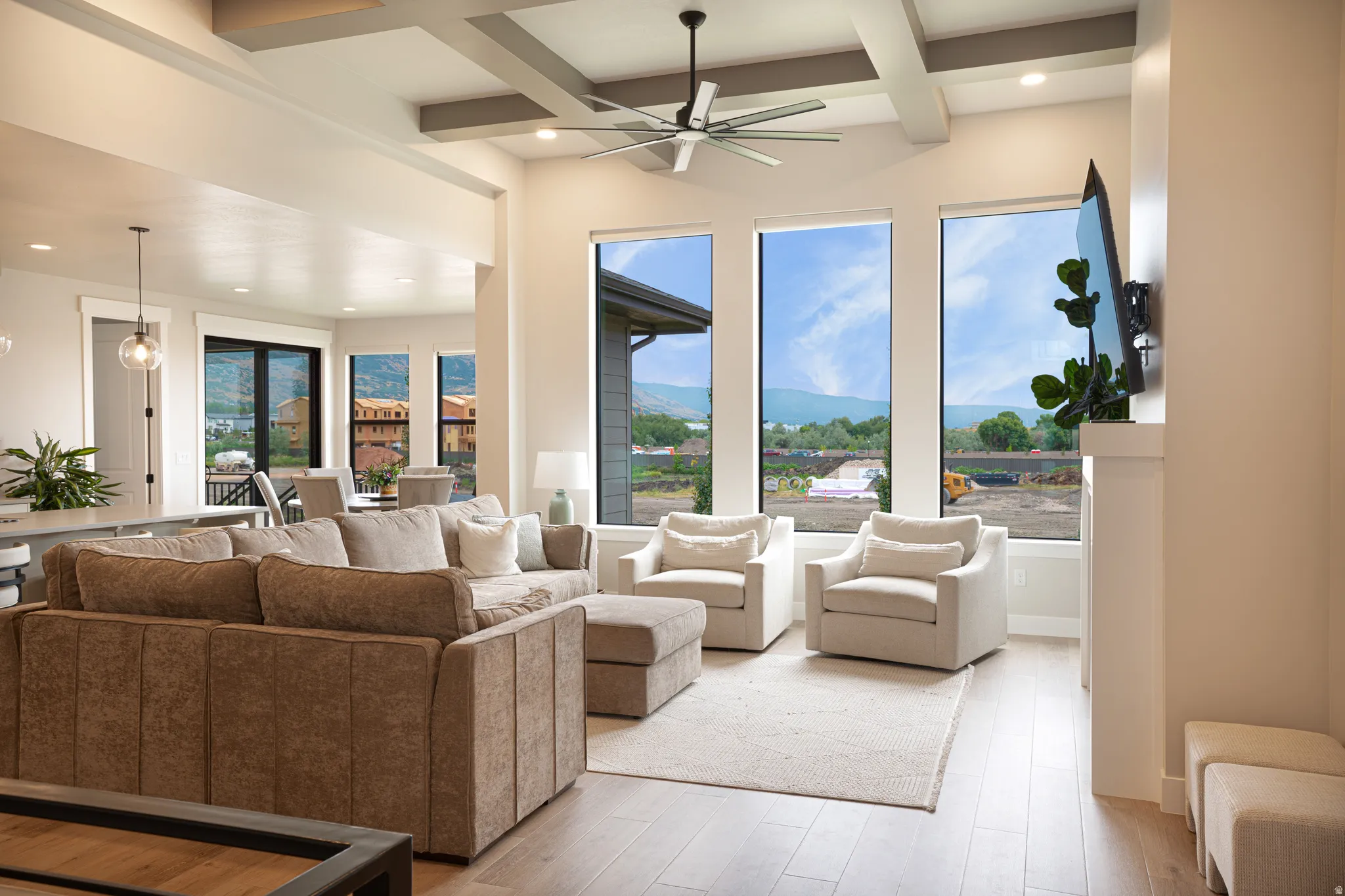 High ceilings featuring exposed beams and a ceiling fan
