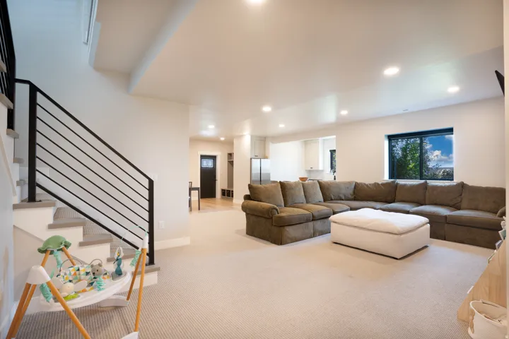 Open-concept living area with recessed lighting and neutral carpeting