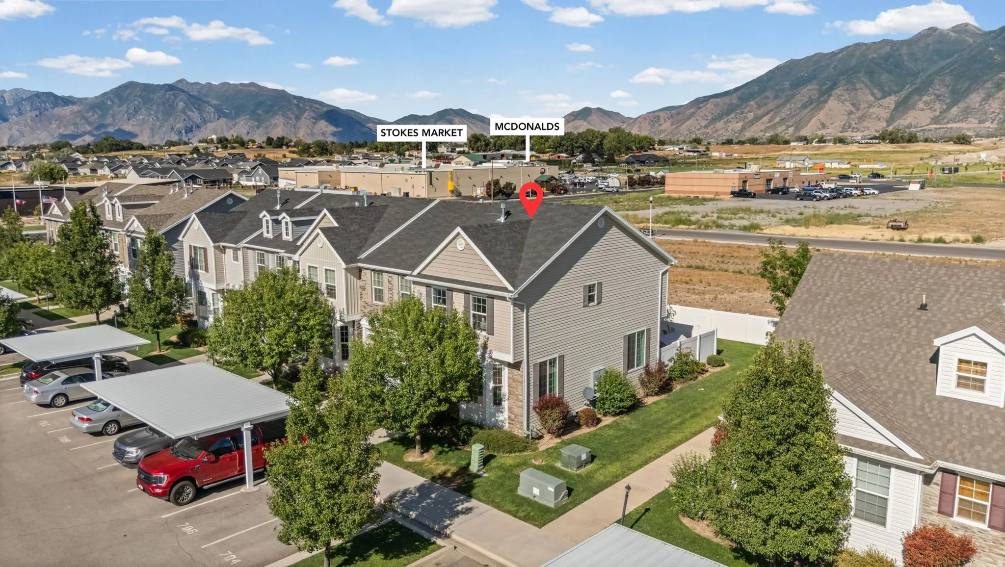 Contemporary multi-story townhome with light gray siding and stone accents