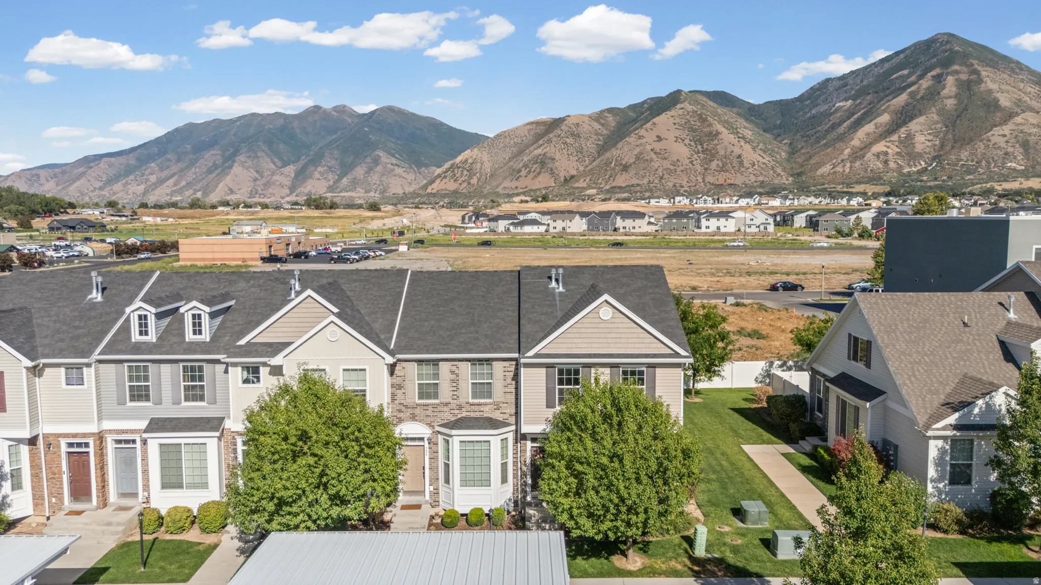 Townhome community featuring varied exterior finishes, established landscaping, and mountain scenery