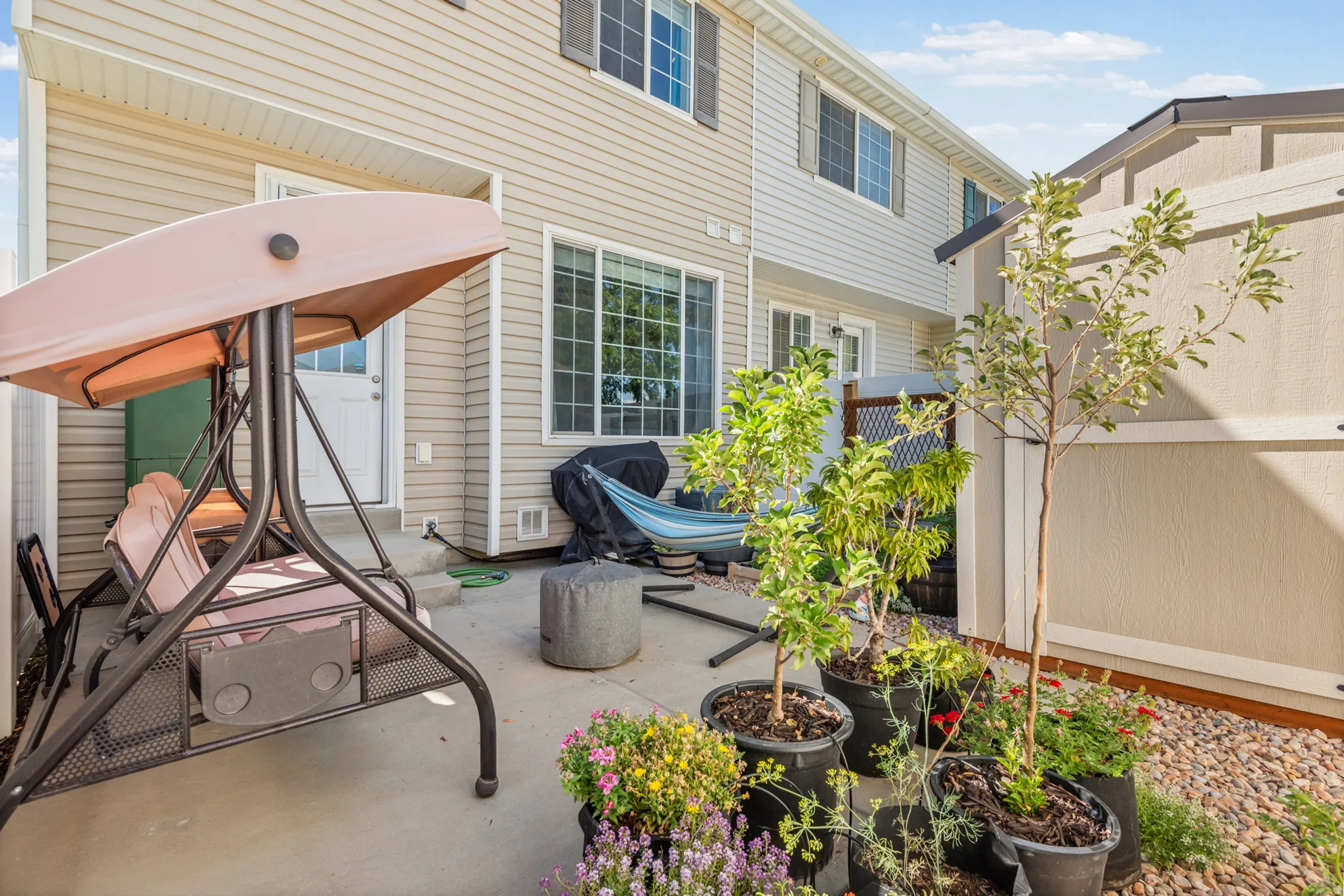 Paved patio with direct access to interior, privacy fencing, and exterior siding