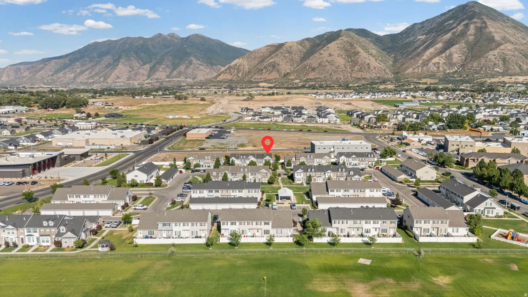 Mountain backdrop with a residential community and open green spaces