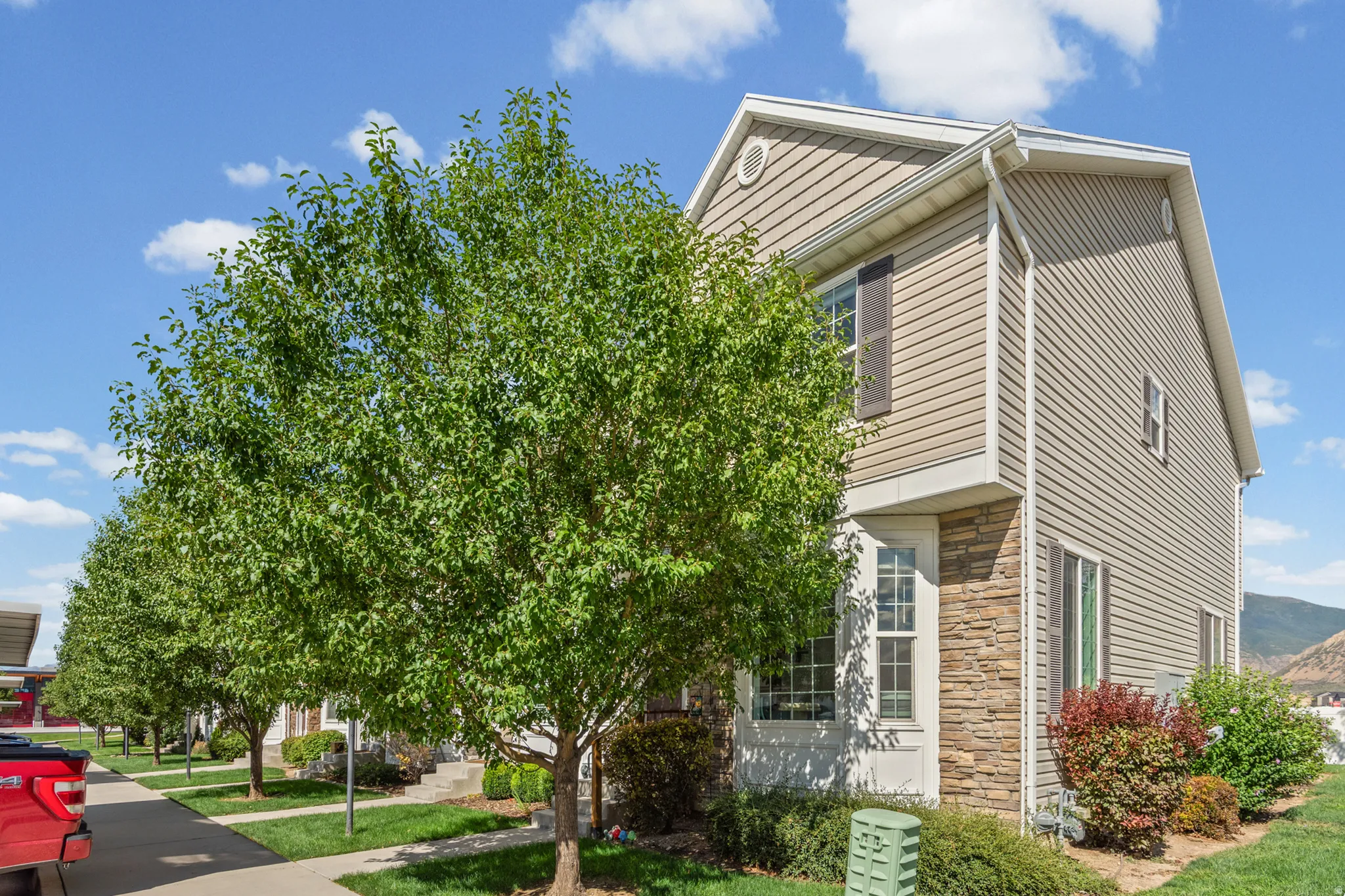 Corner END Two-story residence featuring horizontal siding, stone veneer accents, and exterior shutters