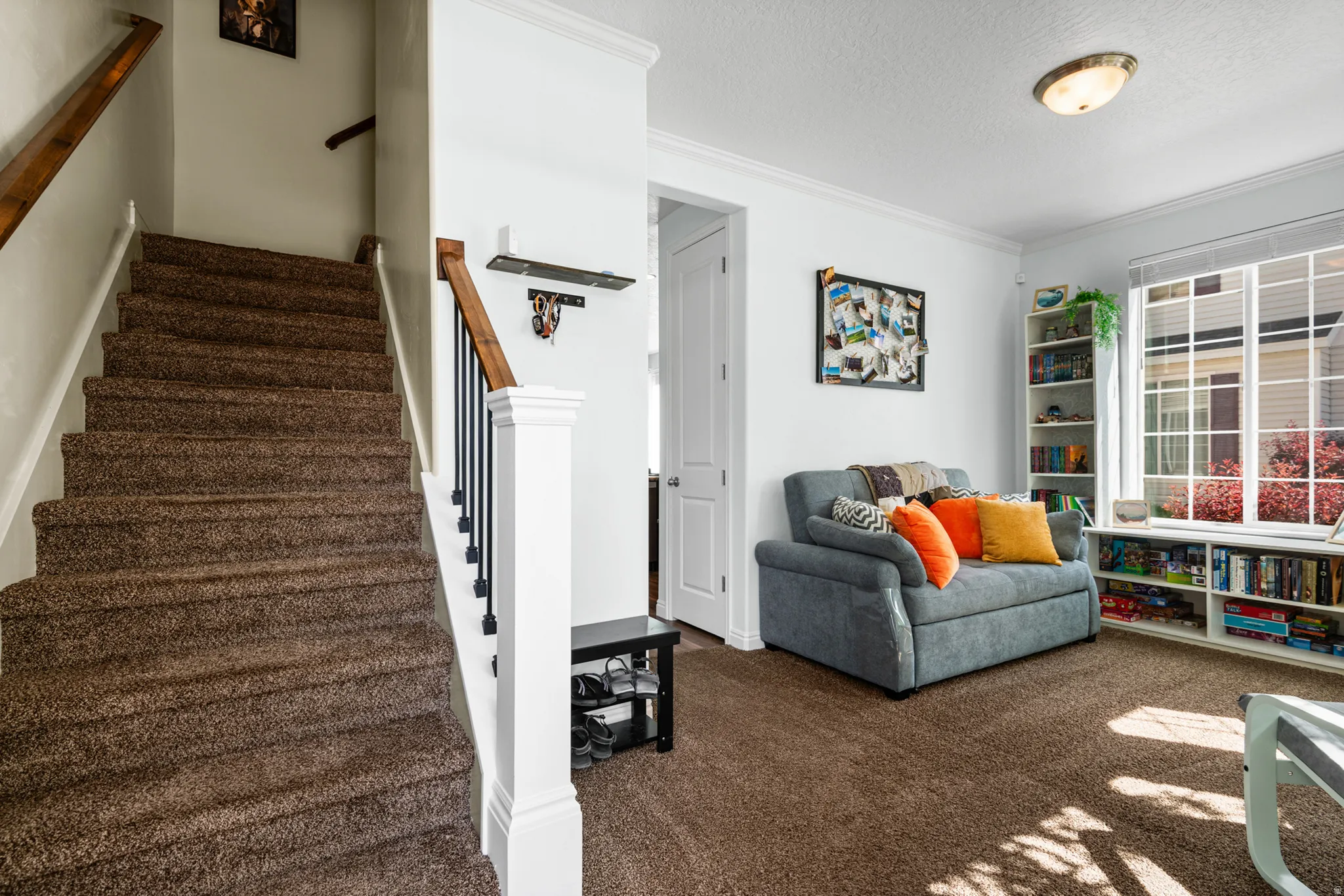 Staircase with wood newel posts and handrails, complemented by black metal balusters