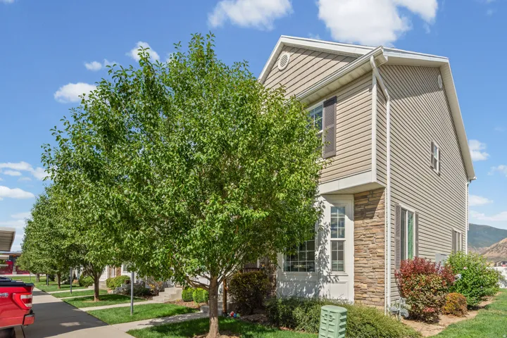 Corner END Two-story residence featuring horizontal siding, stone veneer accents, and exterior shutters