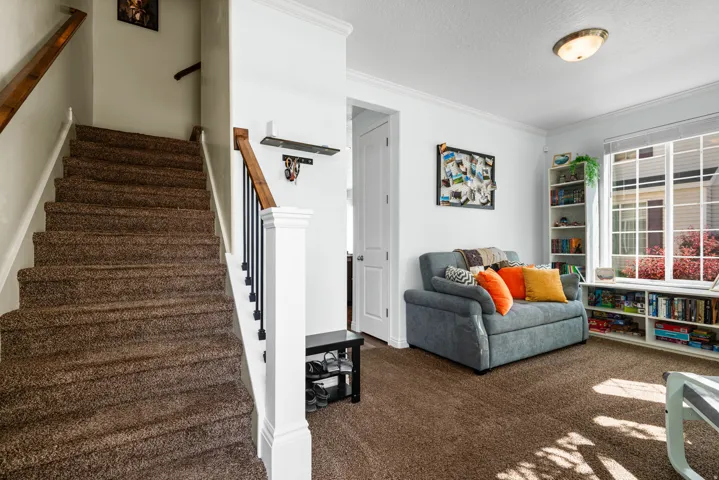 Staircase with wood newel posts and handrails, complemented by black metal balusters