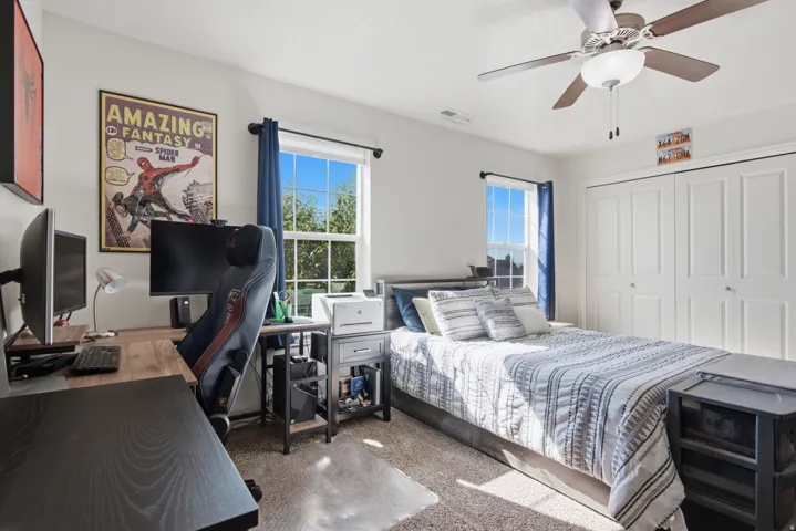 Carpet flooring, multiple windows, ceiling fan with integrated lighting, and bi-fold closet doors