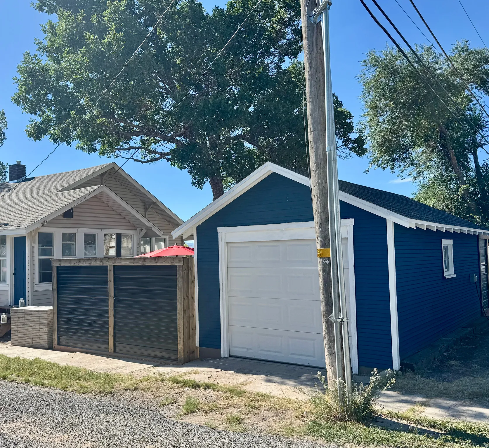 Detached garage featuring blue siding, white trim, and a single white garage door