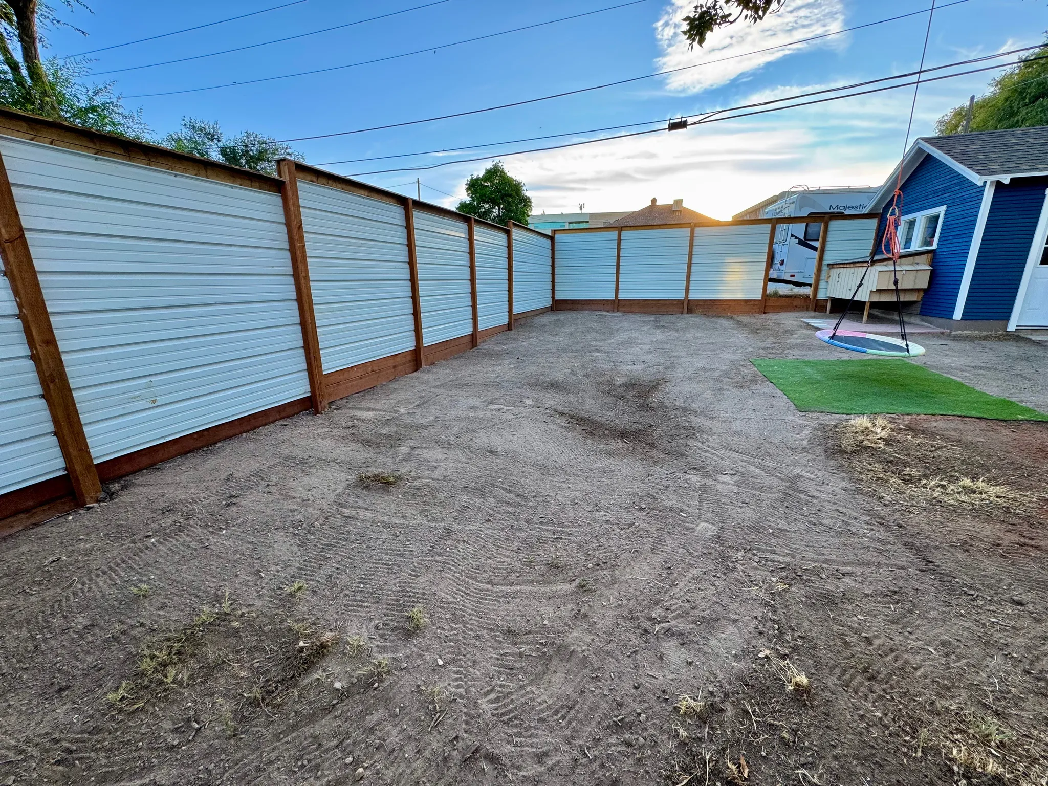 Back Yard area featuring a new privacy fence with wood posts and metal panels