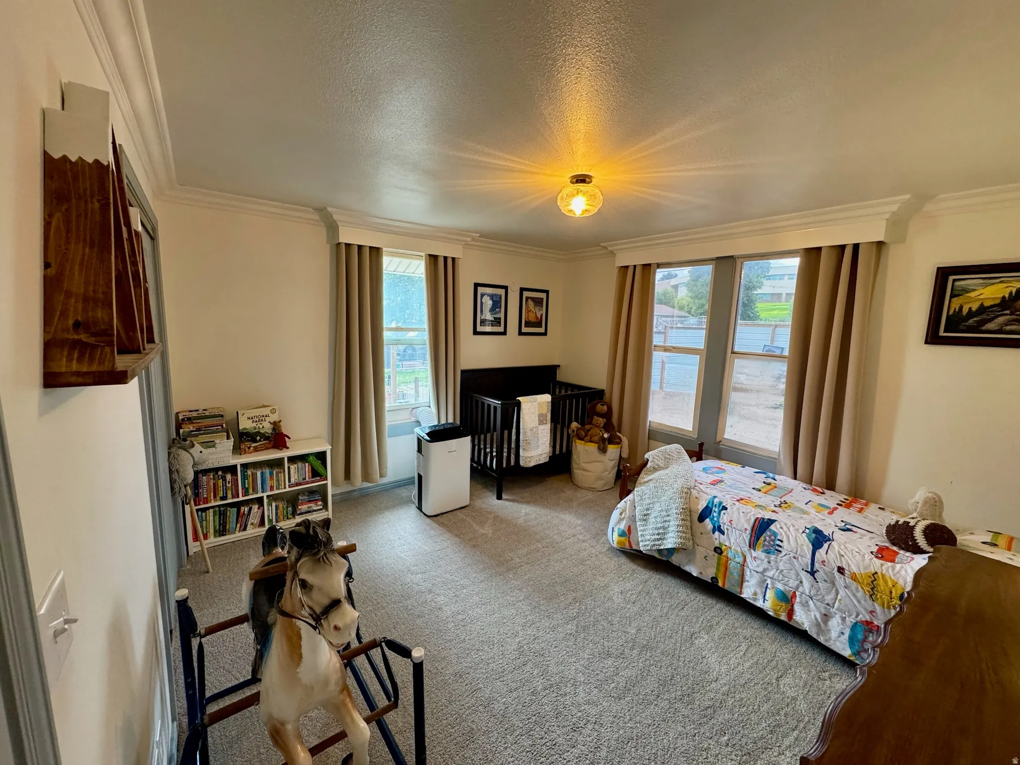 2nd bedroom. Recessed window alcove with multiple windows, crown molding, a built-in wall shelf, and carpet flooring