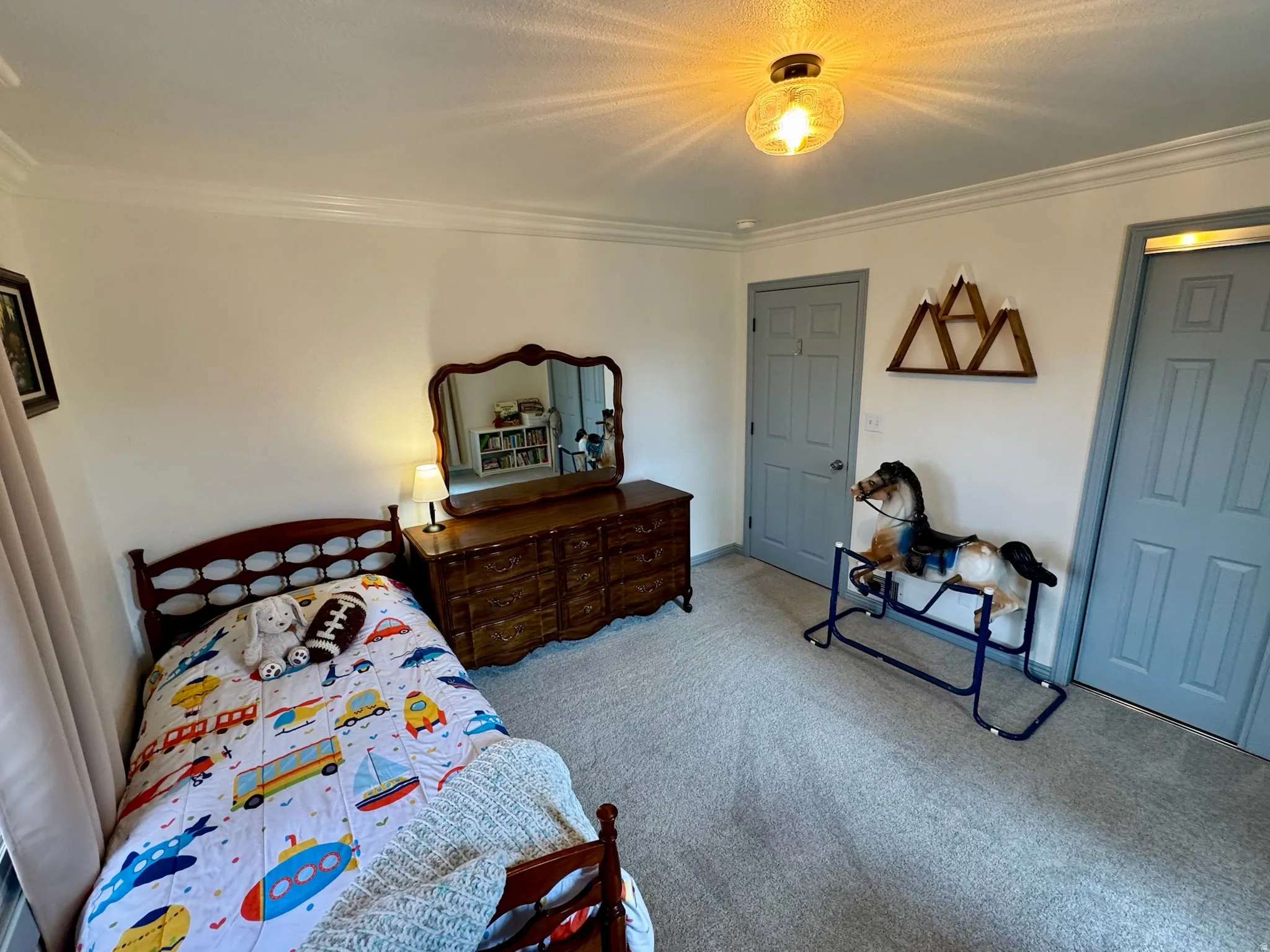 2nd bedroom. Crown molding detail, flush mount ceiling light fixture, two panel interior doors, and textured carpet flooring
