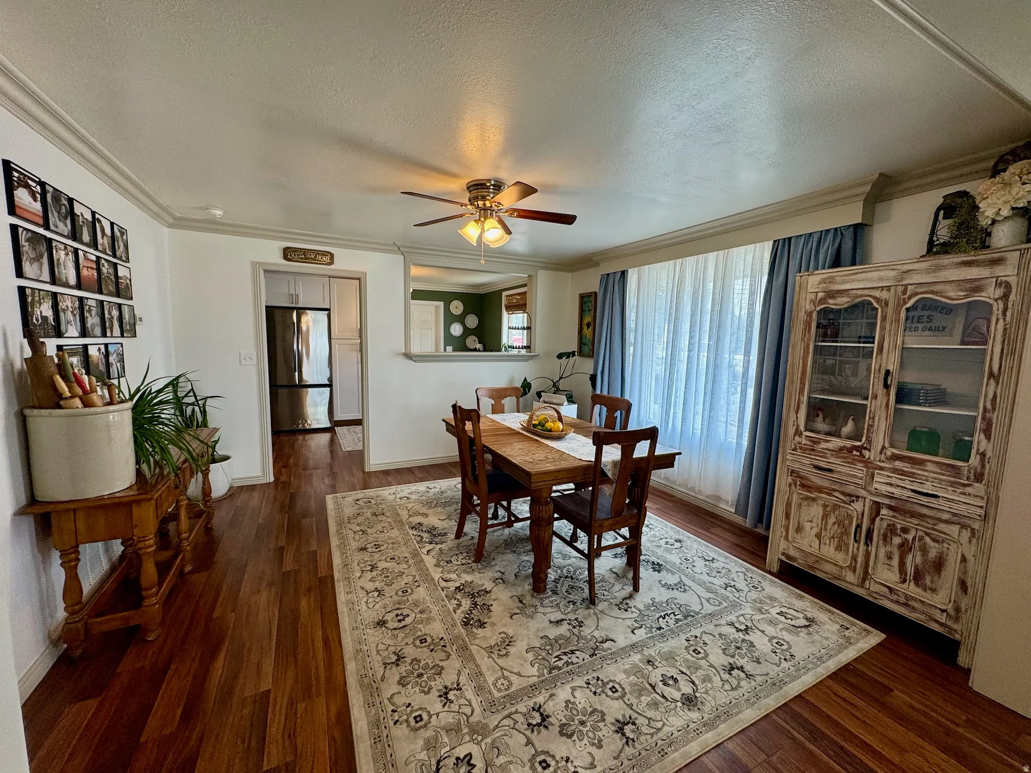 Dining area featuring wood-finish flooring, a ceiling fan, and crown molding
