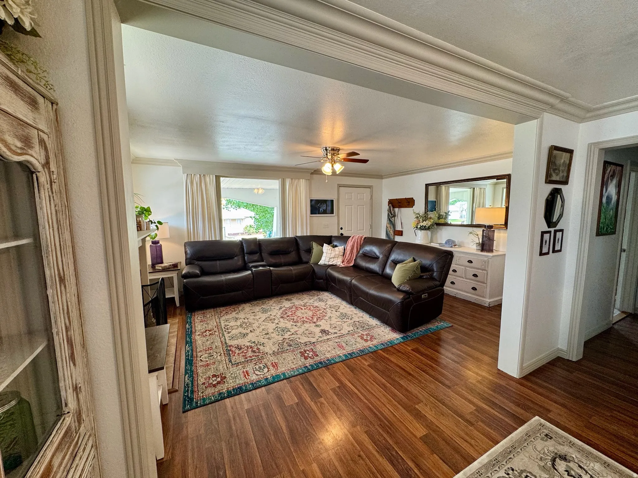 Wood-finish flooring throughout, bright white walls, and decorative ceiling trim