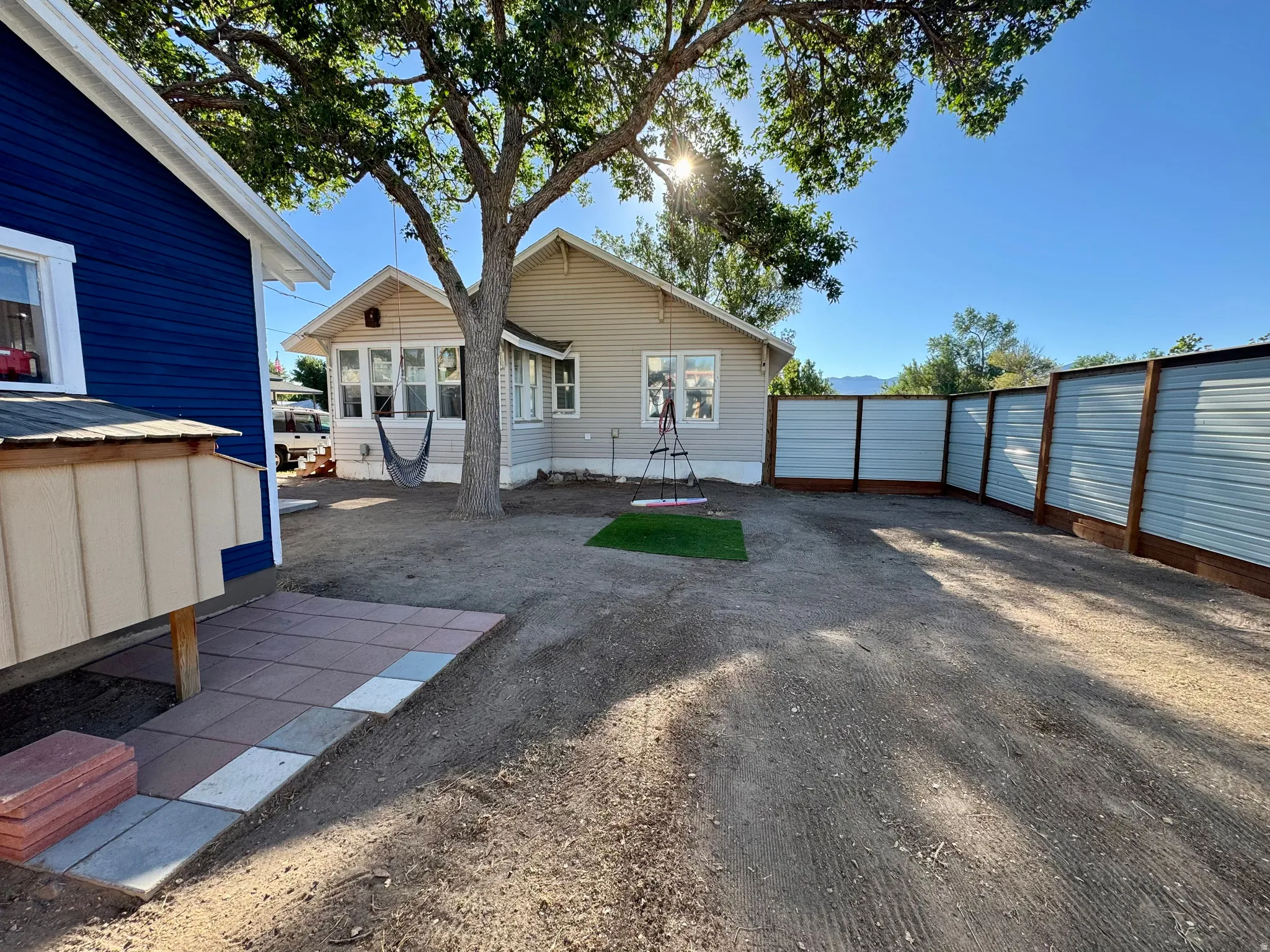 Backyard featuring a privacy fence with wood posts and corrugated metal panels