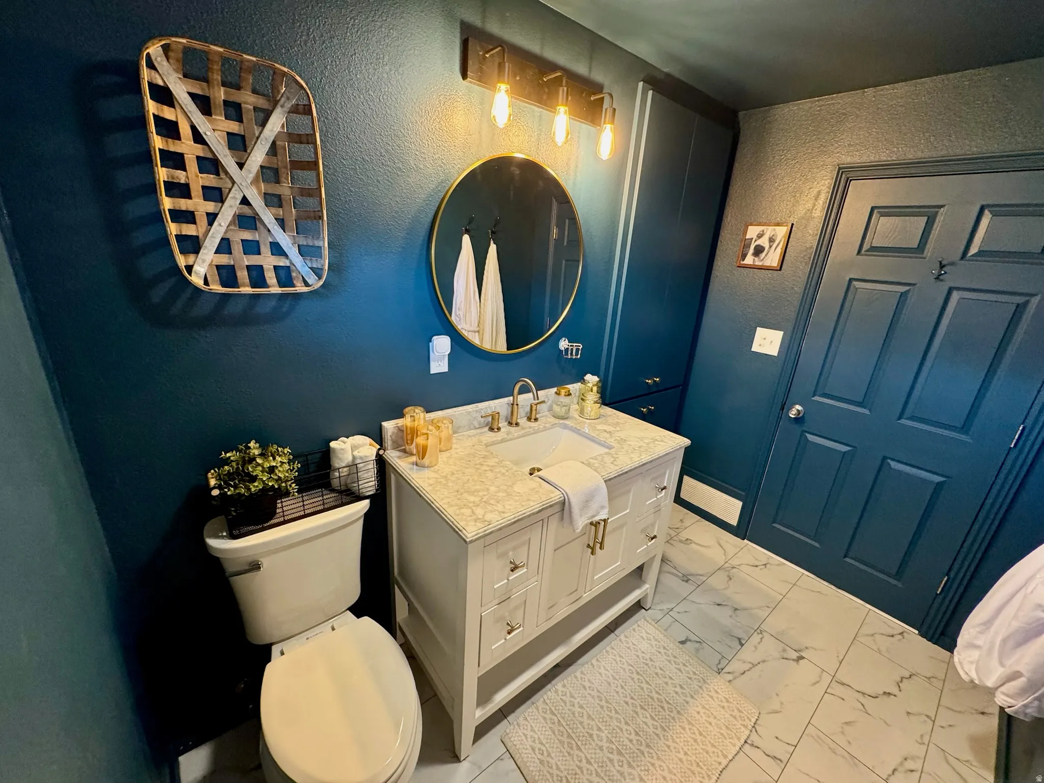 White vanity with gold-finish hardware and a rectangular undermount sink