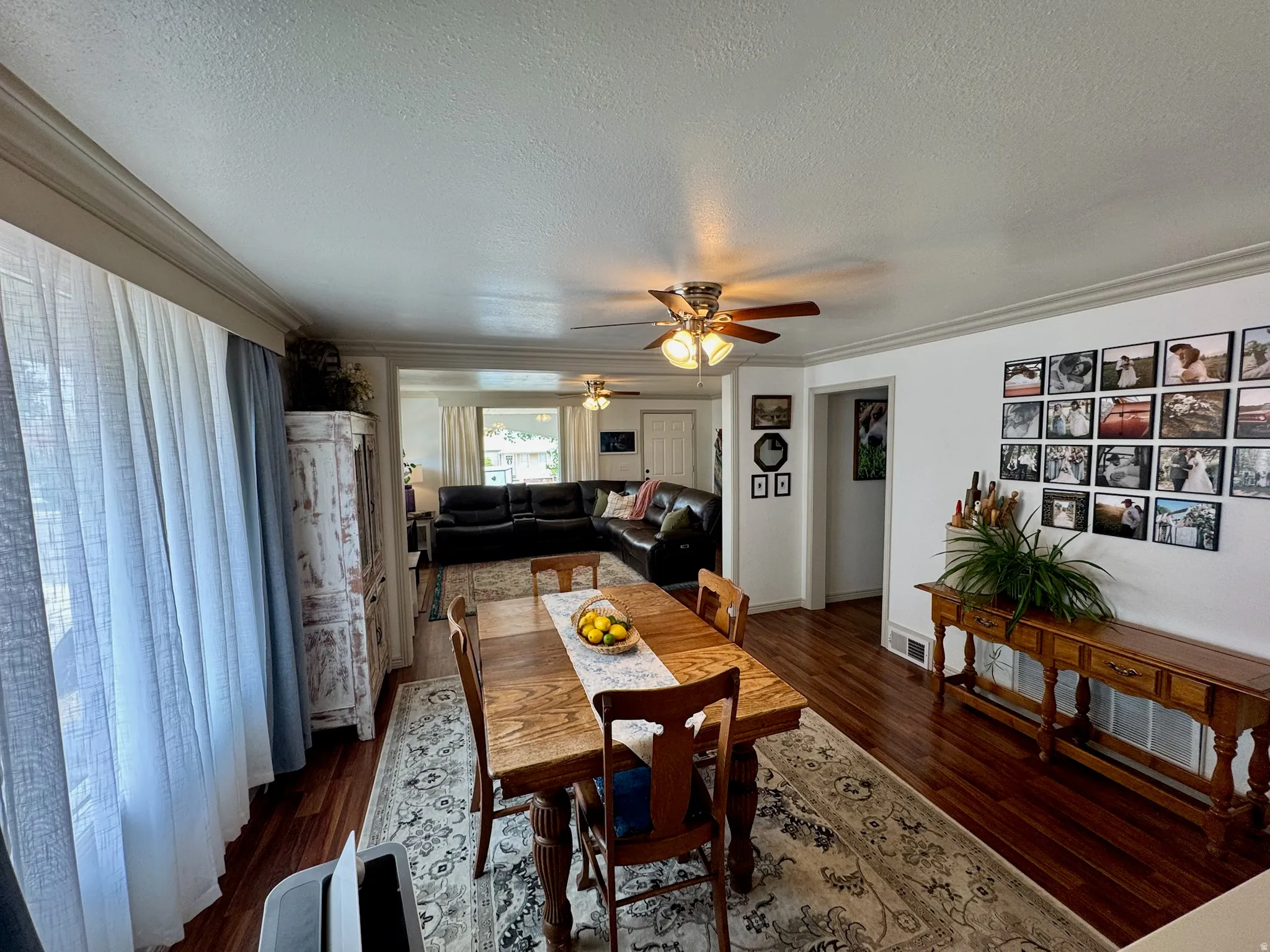 Wood-finish flooring, crown molding, and ceiling fan with lighting
