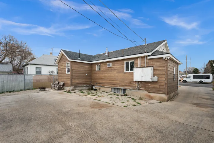 Wood siding exterior with a shingle roof and concrete driveway