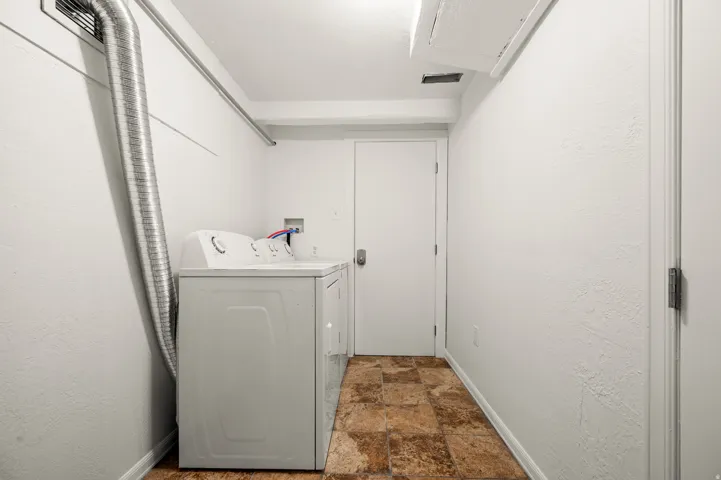 Laundry area featuring tiled flooring, a built-in dryer vent, and a white interior door