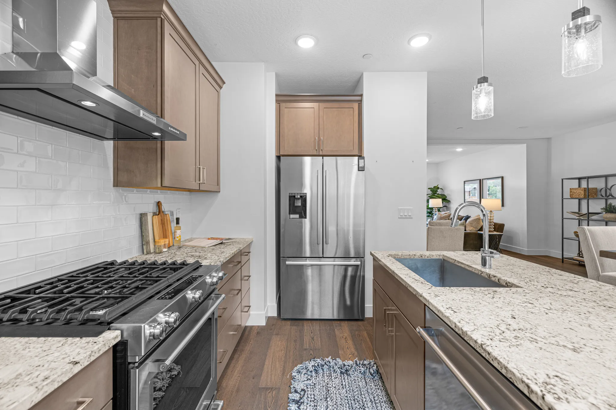 Gourmet kitchen featuring stainless steel appliances, granite countertops, wood-finish flooring, and recessed lighting