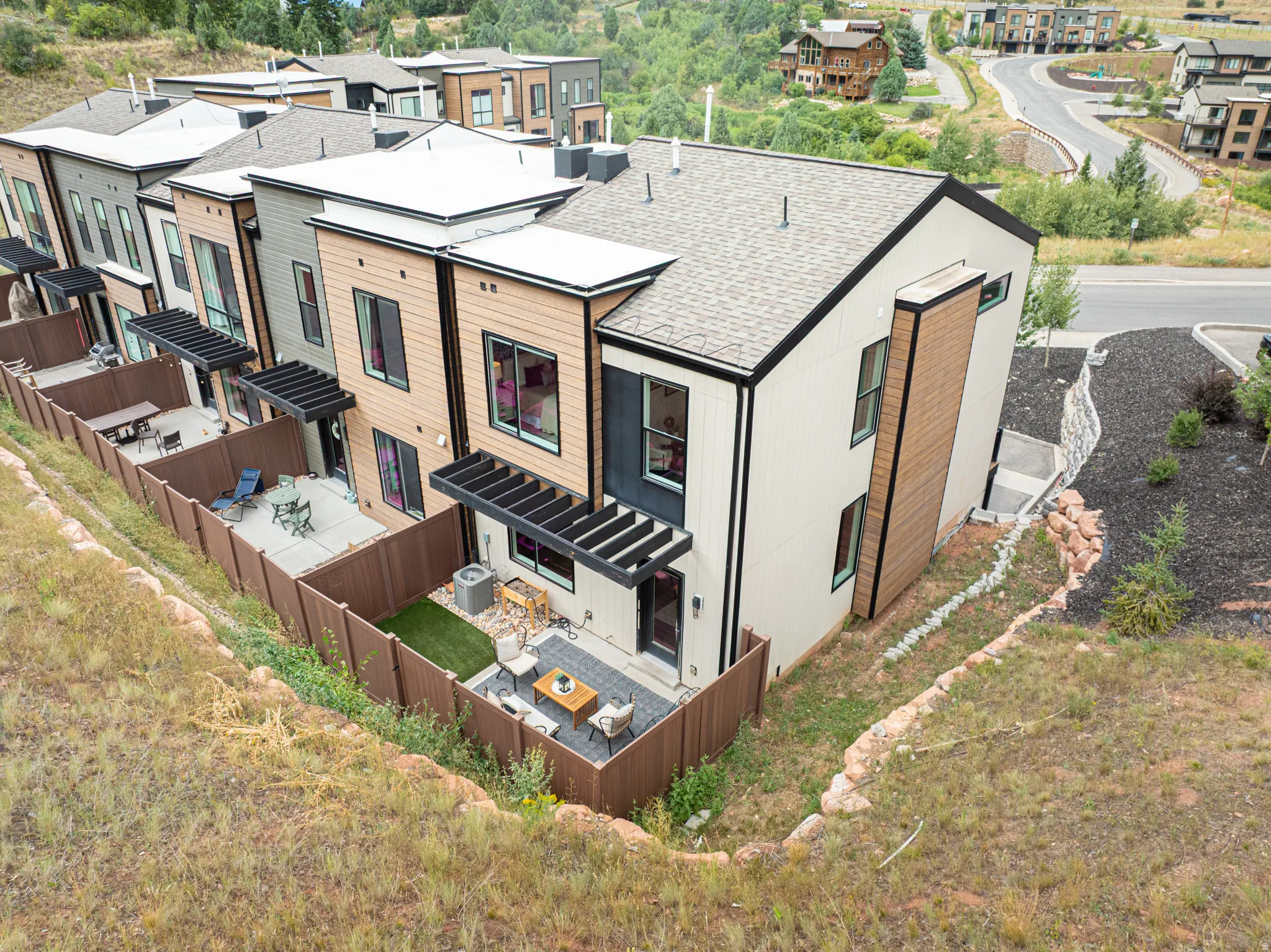 Modern townhome with multi-level architecture, private fenced patios, and contemporary exterior finishes